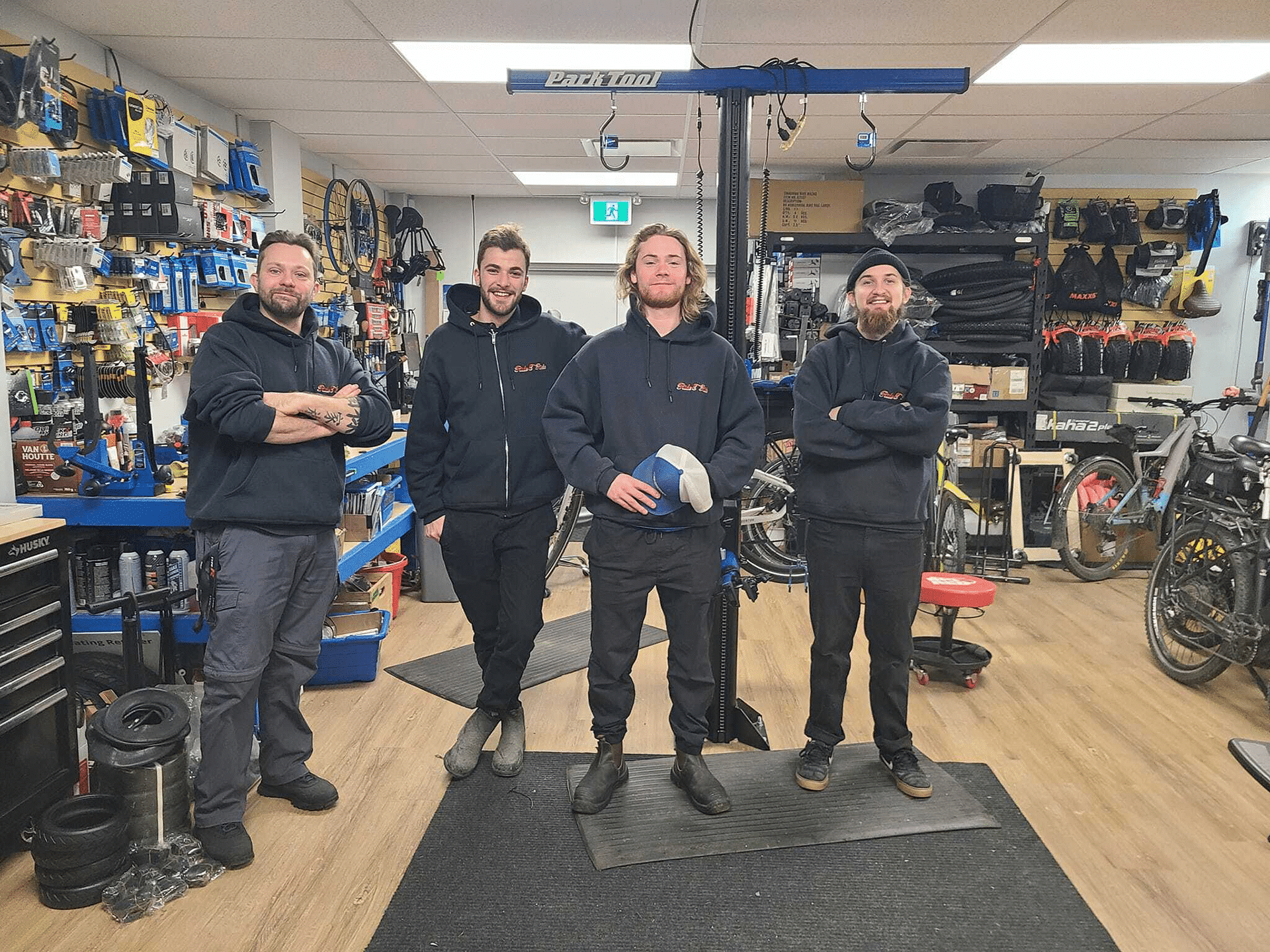 Team of staff at Full Charge Cycles bike shop in the Canada, smiling and posing together in the store.