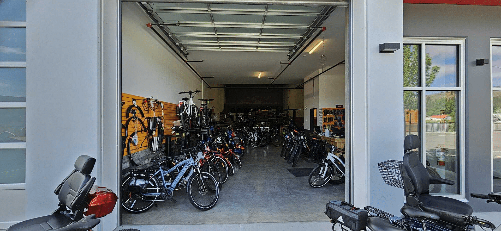 A bike shop named Full Charge Cycles in West Kelowna, featuring numerous bikes parked outside the entrance.